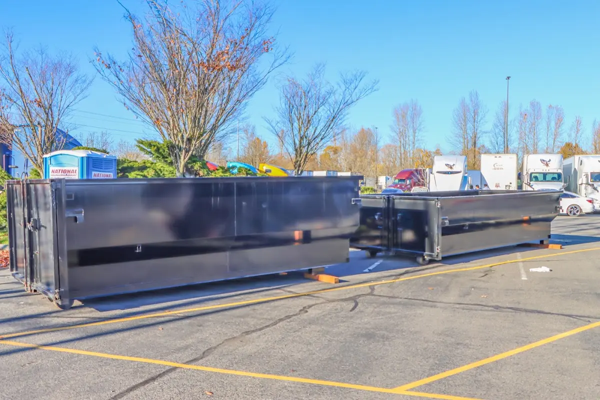 Professional dumpster rental service with roll-off container on residential driveway in Kirby